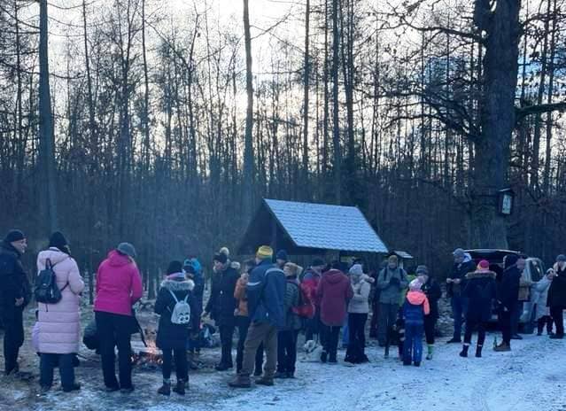 Skupina lidí u ohně v zasněženém lese